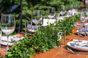 Preparing for an open-air party. Decorated with fresh flowers served tables. Table number. Decoration Details
