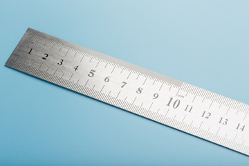 Metal ruler on a blue background close-up with a copy of the space for your text.