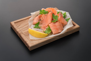 Smoked wild salmon with lemon on wooden background