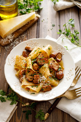 Pappardelle pasta with porcini mushrooms on a white plate, top view