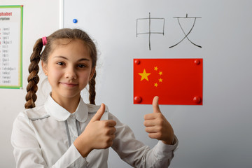 Happy caucasian secondary learner showing thumbs up, happy to study Chinese language. Concept of...