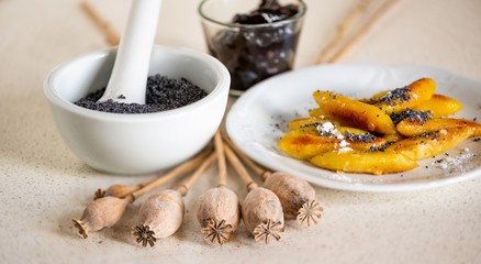 Sweet potato dumpling (wedges) with poppy seeds, poppy heads, plum jam and mortar.
