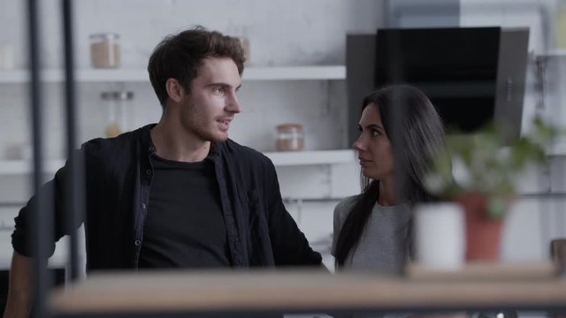 Beautiful young people have fun talking in a homely atmosphere, a tall brown-haired woman and a slender brunette smile and gesticulate