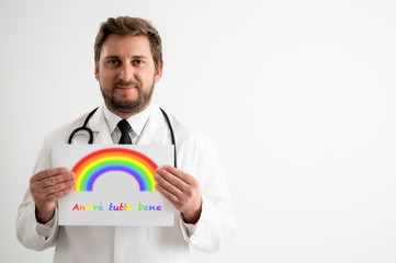 Male doctor with stethoscope in medical uniform holding a white paper rainbow