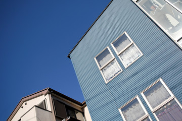 Fototapeta na wymiar Facade of a blue house in front of blue sky in the suburbs of Hibarigaoka, Nishitokyo, Tokyo, Japan