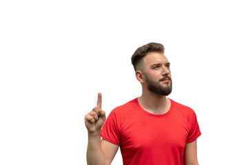 Naklejka premium handsome young man in red t-shirt points finger up isolated on white background. pay attention, way up, look up