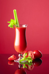 Tomato juice on a reflective background.