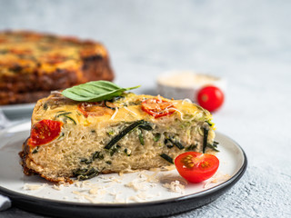 Zucchini pie and ingredients on gray background, copy space. Piece of delicious savory pie with...