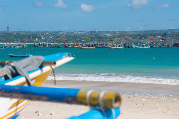 Many traditional Balinese fishing boats are floating in the blue sea.