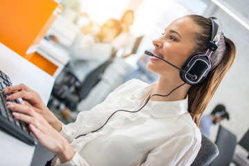 Closeup portrait of support phone operator in headset at workplace