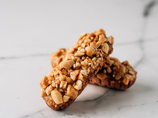 Homemade eclairs with peanut on marble background. Close up view of delicious healthy profitroles with nuts. Copy space for text or design.