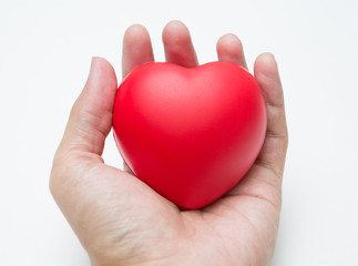 The hand is holding Heart shaped squeeze ball for hand muscle exercise on white background  and copy space