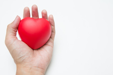 The hand is holding Heart shaped squeeze ball for hand muscle exercise on white background  and copy space