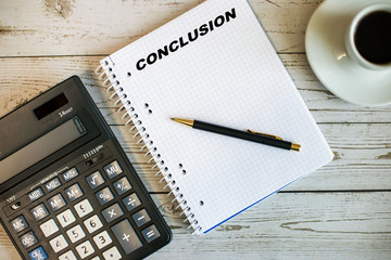 notebook for notes, pen, calculator, cup of coffee on a wooden table