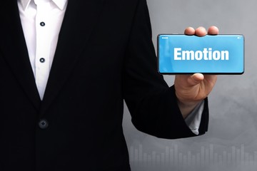Emotion. Geschäftsmann im Anzug hält ein Smartphone in die Kamera. Der Begriff Emotion steht auf dem Handy. Konzept für Business, Finanzen, Statistik, Analyse, Wirtschaft