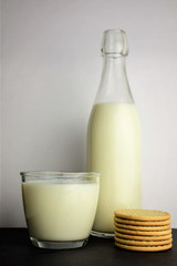 Close-up a glass of milk as main shot along with cookies on slate table