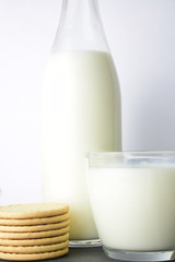 Close-up a glass of milk as main shot along with cookies on slate table