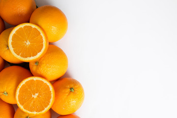Heap of bright juicy whole and sliced orange fruits isolated on white background. Closeup, top view, copy space. Natural vitamin or organic food concept