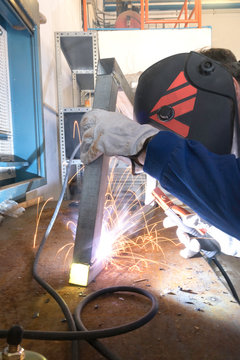 Worker welding metals on the job