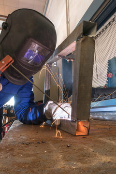 Worker welding metals on the job