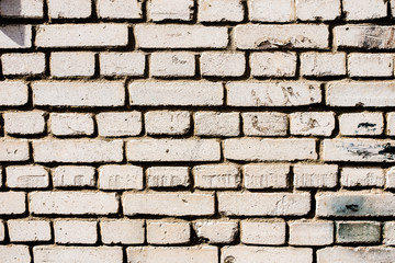Background of an old, dirty, white brick wall with peeling plaster, painted walls, texture
