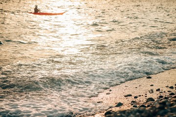 Swimming man on a kayak on a sunny day