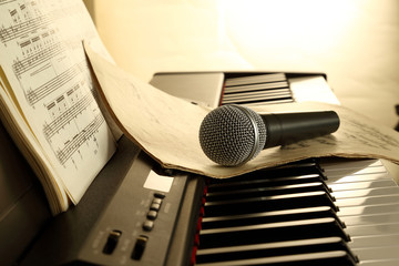 microphone, piano and music paper in backlight