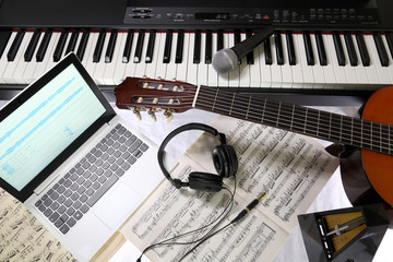 equipment for recording music in the studio, piano, guitar, microphone, headphones, laptop