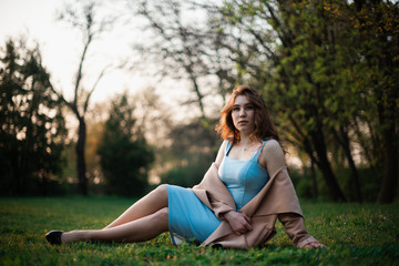 Beautiful young girl in a blue dress in a spring park