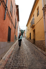 Young tourist woman on narrow cosy street in old town of Sagunto, Spain