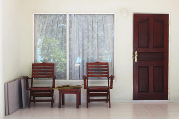 Terrace of white beach bungalow, Maldives vacation background. Entrance to the room number. Wooden table and chairs.
The concept of beach holidays on the islands