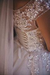bride's back in wedding dress with gems and rhinestones