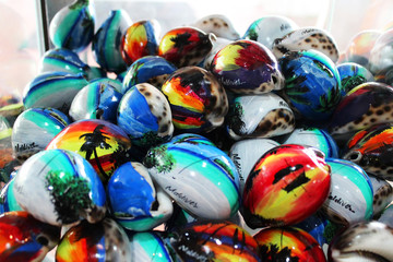 Fototapeta na wymiar Colorful souvenirs in the souvenir shop on tropical Maldives island. Decorated and painted sea shells. 