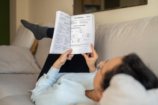Woman lies on the sofa, learning english at home