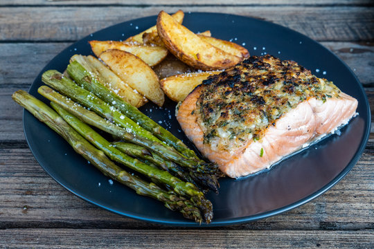 Grilled salmon fillet with herb crust with asparagus and potato wedges
