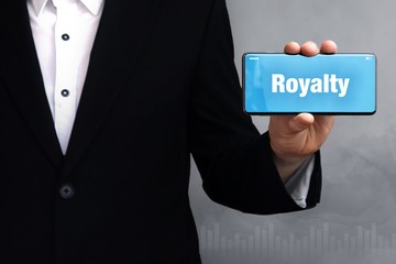 Royalty. Geschäftsmann im Anzug hält ein Smartphone in die Kamera. Der Begriff Royalty steht auf dem Handy. Konzept für Business, Finanzen, Statistik, Analyse, Wirtschaft