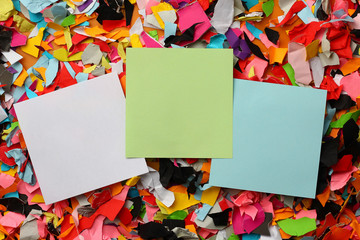 Three blank stickers with place for text on the background of a huge number of pieces of torn...