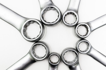 Chrome ring spanners of various sizes were in contact with each other. Isolated on a white background.