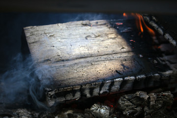 Firewood in the grill and the blurred flames blaze wildly around