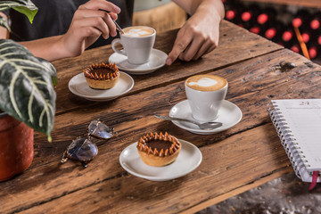 coffee with milk with mini cake glasses on wooden table