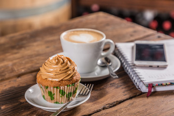 coffee with milk with cupcake note and cell phone
