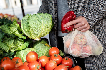 man using reusable mesh bags at a greengrocer