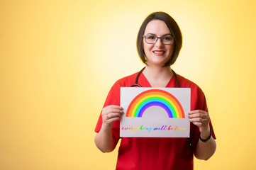 Beautiful woman doctor with stethoscope, wearing red scrubs holding a white paper