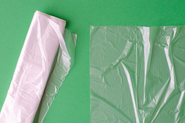 plastic bag and polyethylene sack roll on green background.