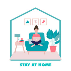 Stay at home concept.Woman sitting on an armchair with laptop  in her living room in period of self isolation and social distancing during COVID-19 virus epidemic. Freelance or studying concept.