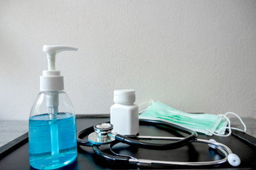 Pictures of alcohol gels medical surgical masks stethoscope and medicine bottles on the hospital table