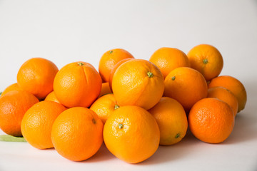 Whole orange fruits pile isolated on white background. Side view, closeup. Natural vitamin or organic food concept