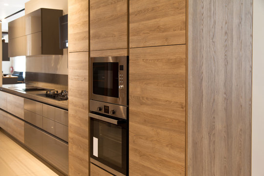Interior of modern kitchen equipment, grey and oak cabinets