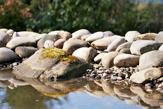 Teich, dreilagig, Steine, Wasser, Spiegelung, Geb&uuml;sch im Hintergrund, Stein mit Moos bewachsen, Gartenarbeit