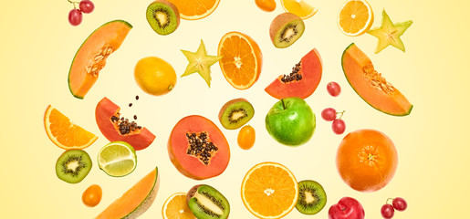 Flying fruits healthy summer color background. Papaya, orange, kiwi, melon. Levitation, falling fly fruit. Tropical creative concept. Colorful fruity summertime vivid design